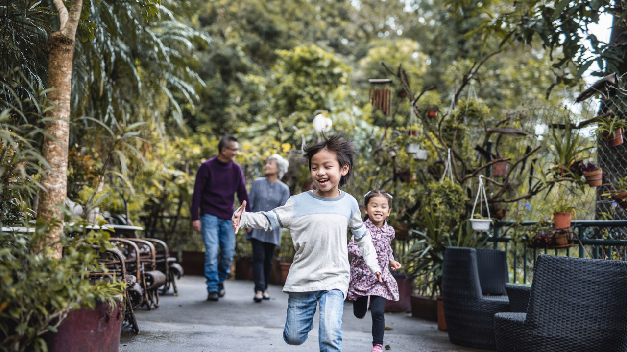 A little boy running in front of his parents
